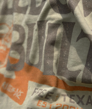 Close-up of a tan t-shirt with the text 'Freedom is buil.' Brand: Free is Life
