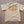 Beige t-shirt with 'Freedom is Built' text on a textured surface
