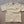 Beige t-shirt with a logo on a concrete surface