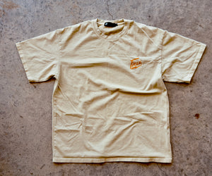Beige t-shirt with a logo on a concrete surface