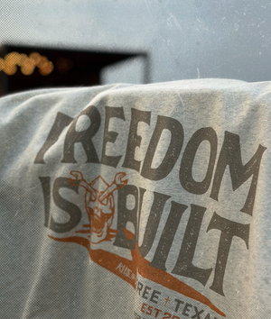 Textured hoodie with 'Freedom is Built' printed on it, featuring a logo.