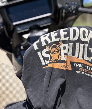 Black t-shirt with 'Freedom is Built' text and graphics on a motorcycle seat. Brand: Free is Life