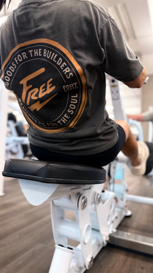 Person wearing a black t-shirt with a logo and text in a gym setting