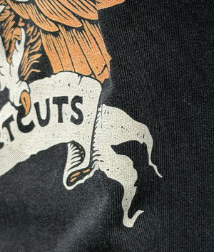 Close-up of a black shirt with a graphic design featuring an eagle and text.