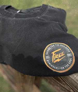 Black t-shirt with a circular logo on a wooden surface