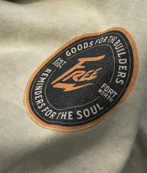 Close-up of a patch on a beige fabric with text and branding.
