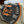 Tan shirt with closeup of graphic on back hanging on wooden fence.