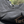 Close-up of a gray hoodie with a brand logo on a blurred natural background