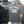 Man wearing a t-shirt with 'Rise Above' design and text, standing next to a vehicle.